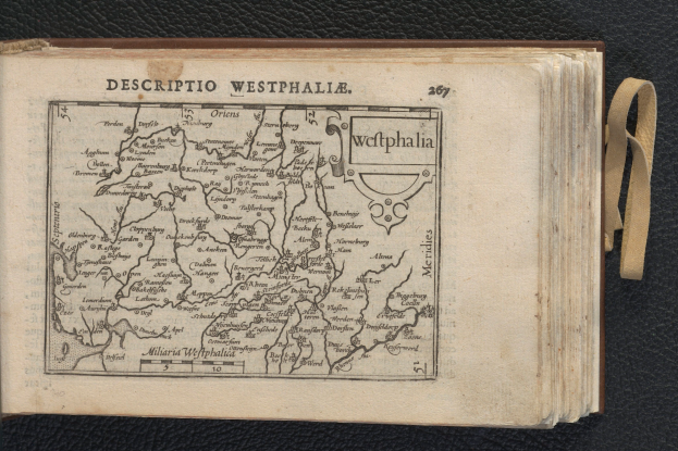 Ein aufgeschlagenes Buch mit einer detaillierten Karte der westfälischen Geographie auf schwarzem Hintergrund.