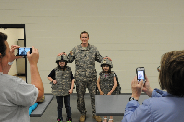 Eine Gruppe von Menschen, die stehen, wobei einige wenige ein Handy halten.