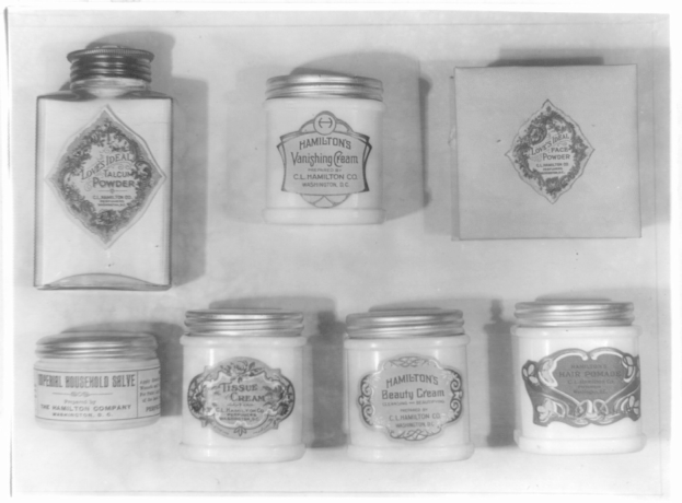 Schwarzes und weißes Foto eines Regals mit ordentlich angeordneten Cremegläsern, die alle mit verschiedenen Arten beschriftet sind.