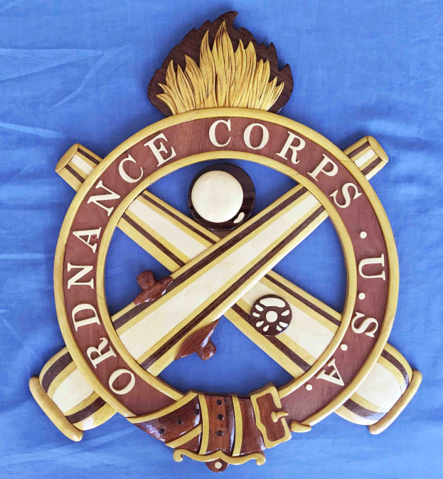 Holzschild mit "Ordnance Corps"-Text, verziert mit einem geschnitzten weißen Stern auf einem navyblauen Hintergrund mit goldener Umrandung, auf blauem Tuch in fetter schwarzer Schrift montiert.