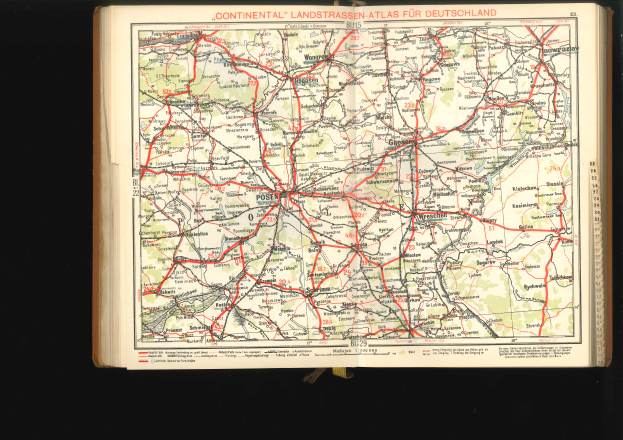 Ein aufgeschlagenes Buch mit einer detaillierten Deutschlandkarte mit Straßen und Autobahnen auf schwarzem Hintergrund.