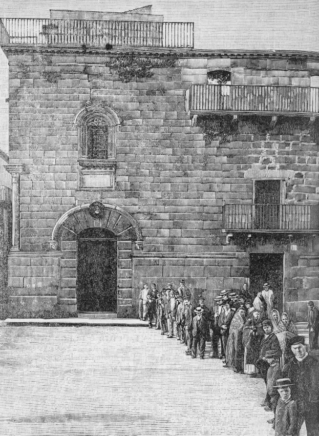 Schwarzes und weißes Foto einer Gruppe von Menschen, die vor einem Gebäude mit Fenstern, Geländern und einer Tür stehen, mit der Beschriftung "Jüdische Gefangene am Eingang zur Synagoge in Jerusalem" unten.