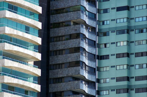 Verschiedene Gebäude in unterschiedlicher Höhe und Gestaltung sind in einer urbanen Umgebung zu sehen.