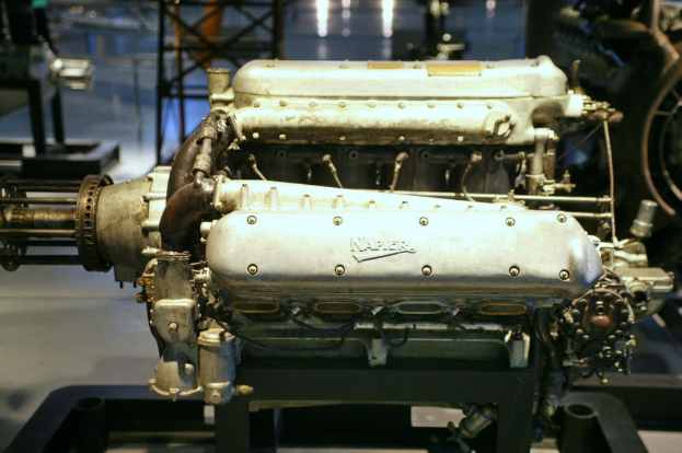 Eine Maschine mit Text darauf befindet sich in der Mitte, mit einem schwarzen Ständer im Hintergrund und einer weiteren Maschine auf der rechten Seite.