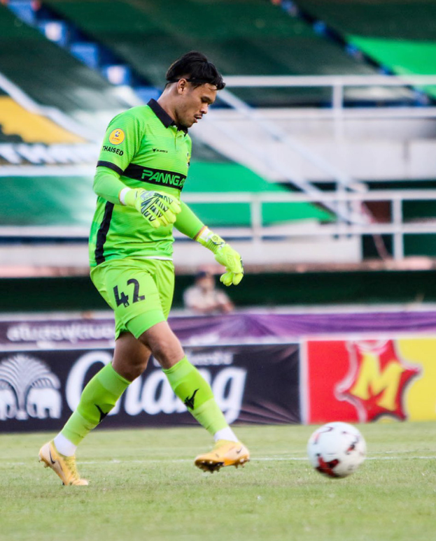 Ein Mann in einem grünen Torwarttrikot kickt einen Fussball auf einem grünen Feld in einem Stadion, mit Bannern im Hintergrund, die "Chivas USA vs Mexiko-Stadt, 3-1, Copa Libertadores" anzeigen.