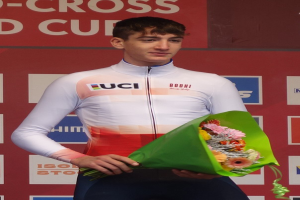 Ein Mann steht triumphierend auf einem Podium, hält einen Blumenstrauß in der Hand und hat eine Tafel im Hintergrund, die Freude und Erreichung ausstrahlt.