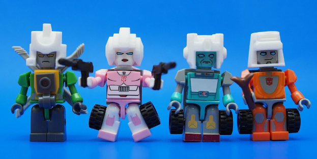 Vier Roboterspielzeuge sind auf einer blauen Oberfläche angeordnet.