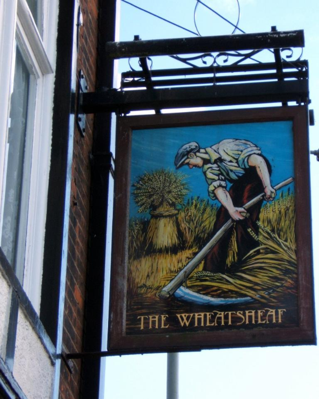 Eine Person steht auf einer Wandtafel, die an einem Gebäude befestigt ist und hält ein Schwert.