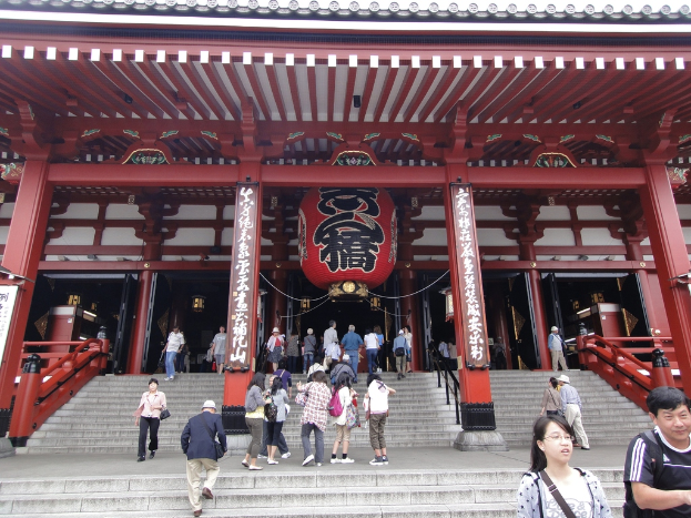 Eine Gruppe von Menschen in der Nähe von Säulen, Tafeln und einem Gebäude.