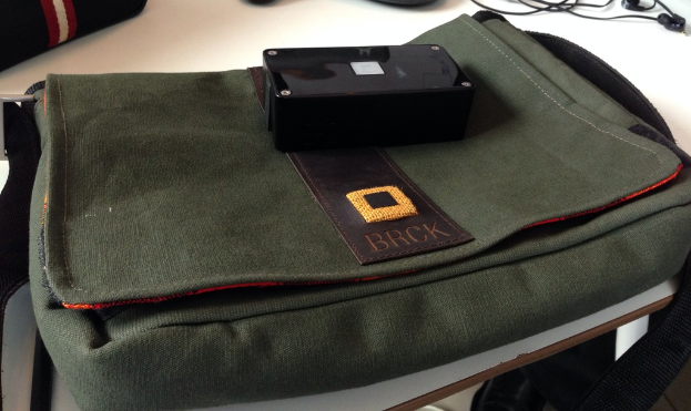 Eine Tasche und Kopfhörer sind auf einem weißen Tisch platziert.