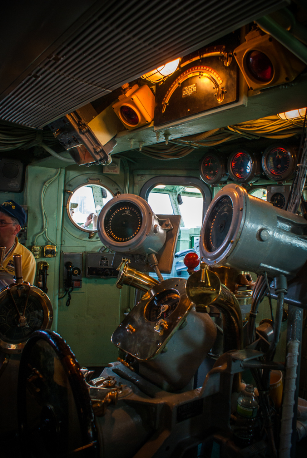 Das Innere eines Zuges mit Sitzen und verschiedenen Gegenständen, eine Person auf der linken Seite in einem gelben T-Shirt.