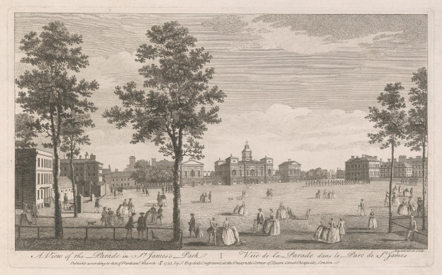 Eine Gruppe von Menschen, die in St. James Park während eines Umzugs stehen und sitzen, mit Bäumen und Gebäuden im Hintergrund bei einem bewölkten Himmel.