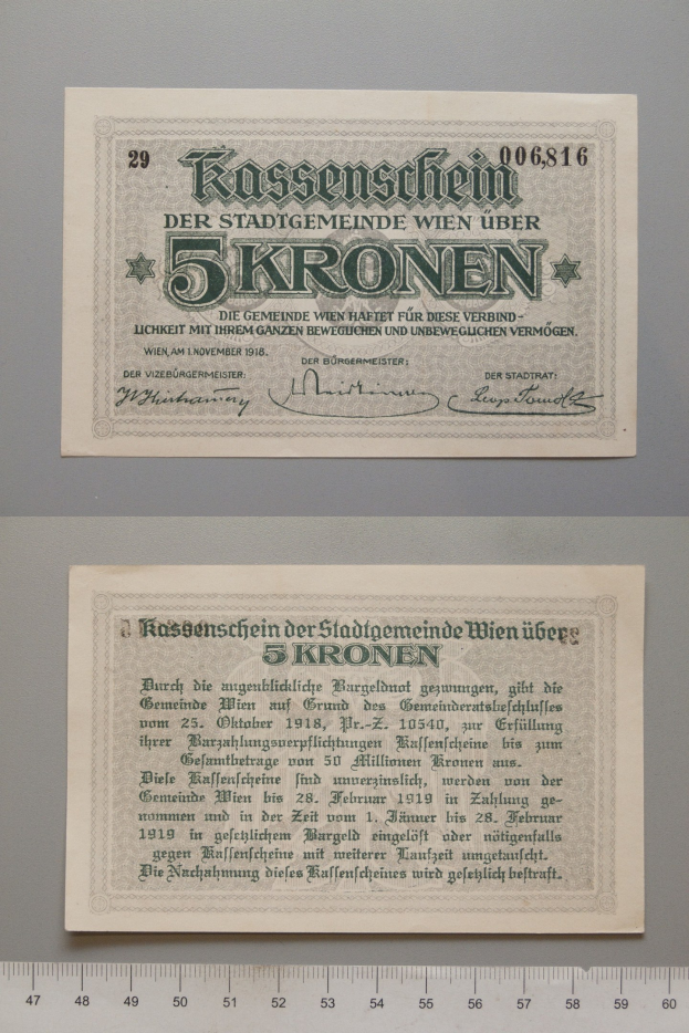 Alte deutsche 5 Kronen-Banknote mit einem Lineal daneben, das bedruckte Text und numerische Werte zeigt.