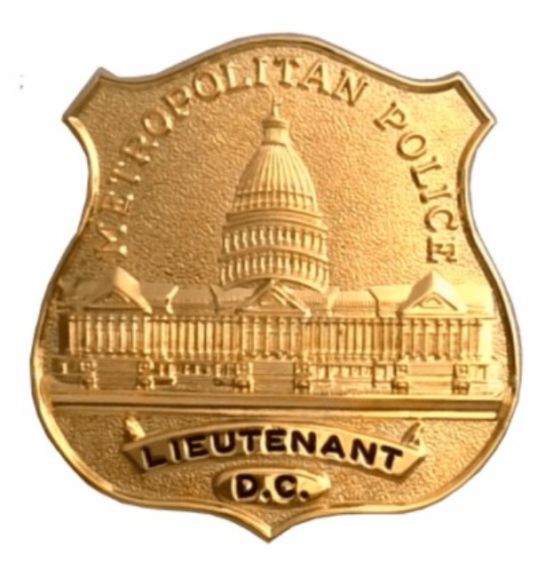 Goldenes Polizeischild mit eingravierter Aufschrift "Leutnant DC" in der Mitte auf einem weißen Hintergrund.