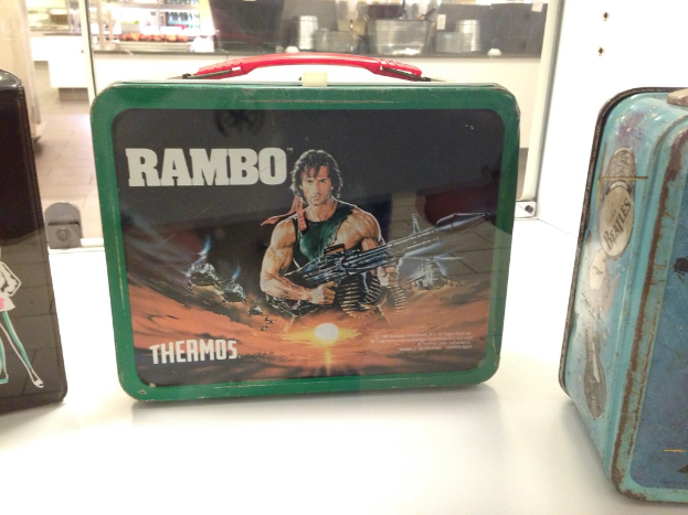 Ein Mann hält eine Waffe mit einer Tasche in der Mitte und einen Eisenkasten auf der rechten Seite.