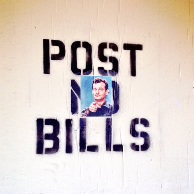 Eine Wand mit Text und einem Foto eines Mannes in einem schwarzen Hemd.