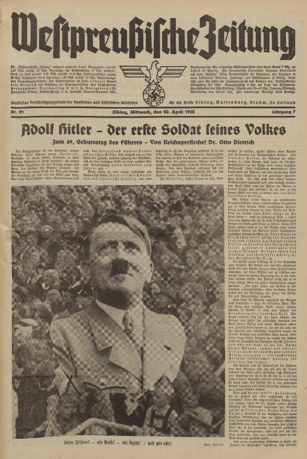 Adolf Hitler, gekleidet in einem schwarzen Anzug und weißem Hemd, steht vor einer Menge auf der Titelseite einer deutschen Zeitung mit der Überschrift "Adolf Hitler - Der Erte Soldat Feines Volkes".