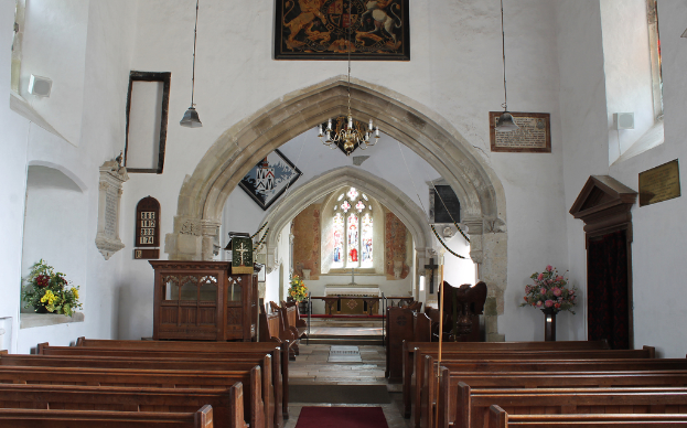 Eine Kircheninnenseite mit Blumenvasen, Bänken, Fotorahmen und Lampen.