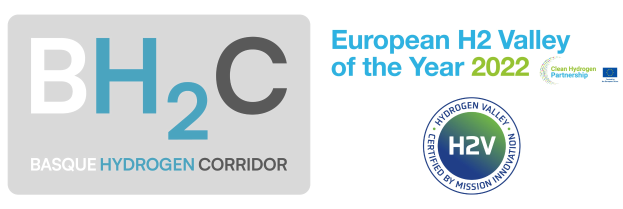 Das Logo des European H2 Valley of the Year 2022 zeigt einen blauen Kreis mit einem weißen Wasserstoffsymbol in der Mitte, umgeben von einem weißen Rand, mit der darunter geschriebenen ├╝berschrift "Basque Hydrogen Corridor" in fetter, schwarzer Schrift.