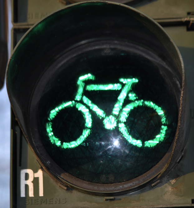 Eine grüne Ampel mit einem Fahrradsymbol, beleuchtet an einer Wand.