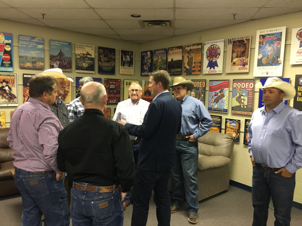 Eine Gruppe von Männern in einem möblierten Raum in ein Gespräch vertieft.